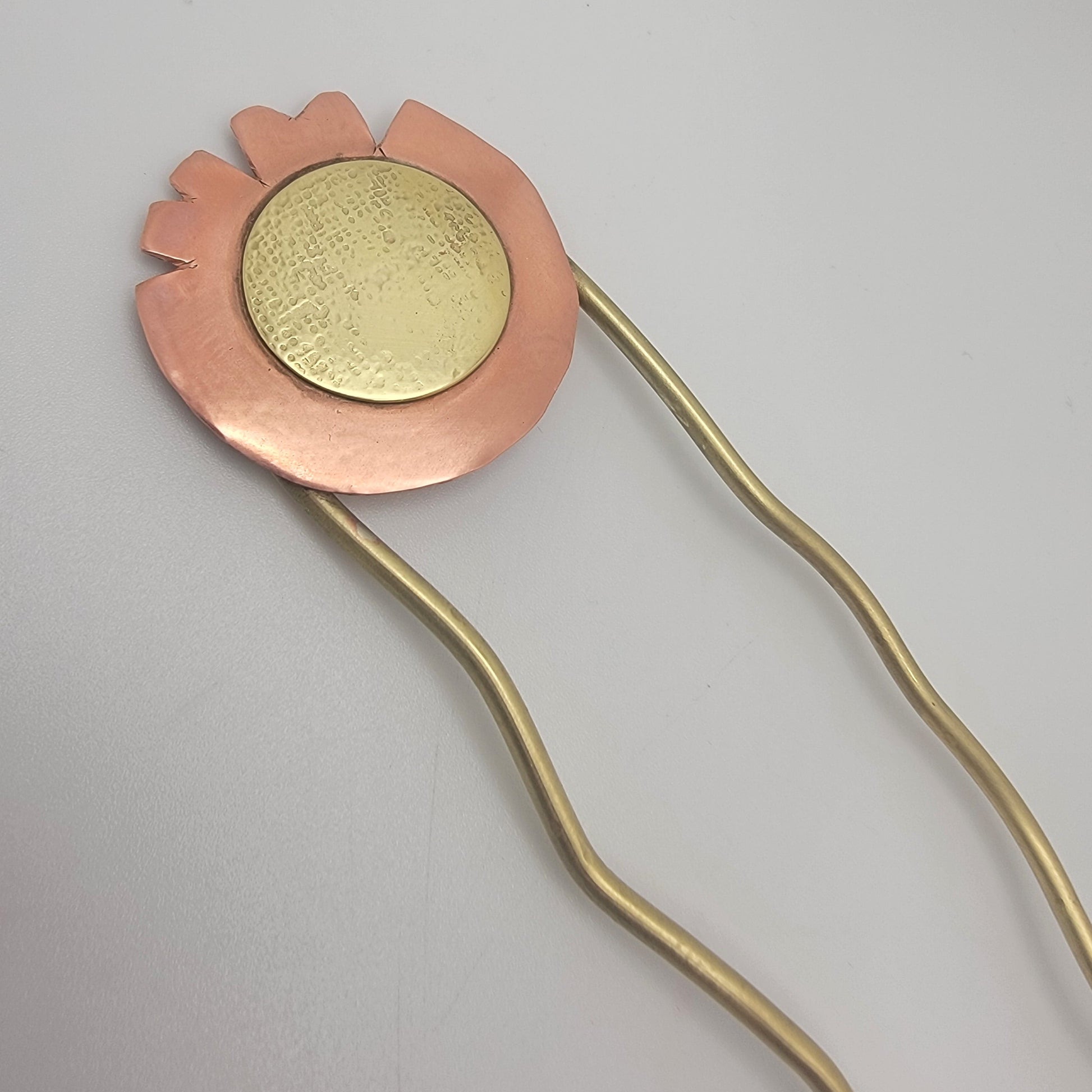 Hairpin with brass and copper accent on a white background