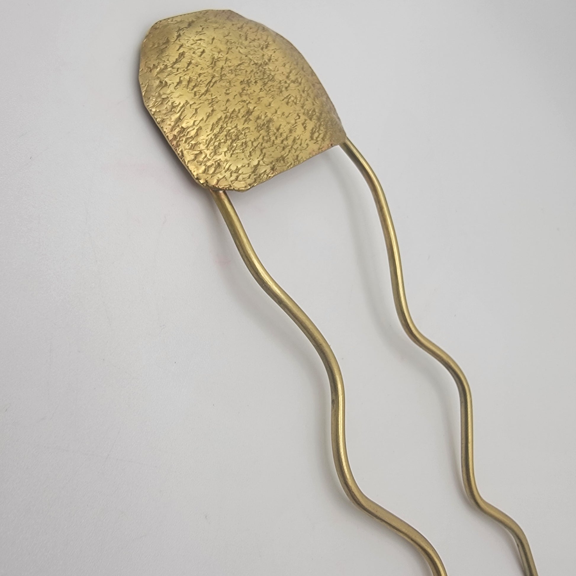 Brass hairpin on a light gray background