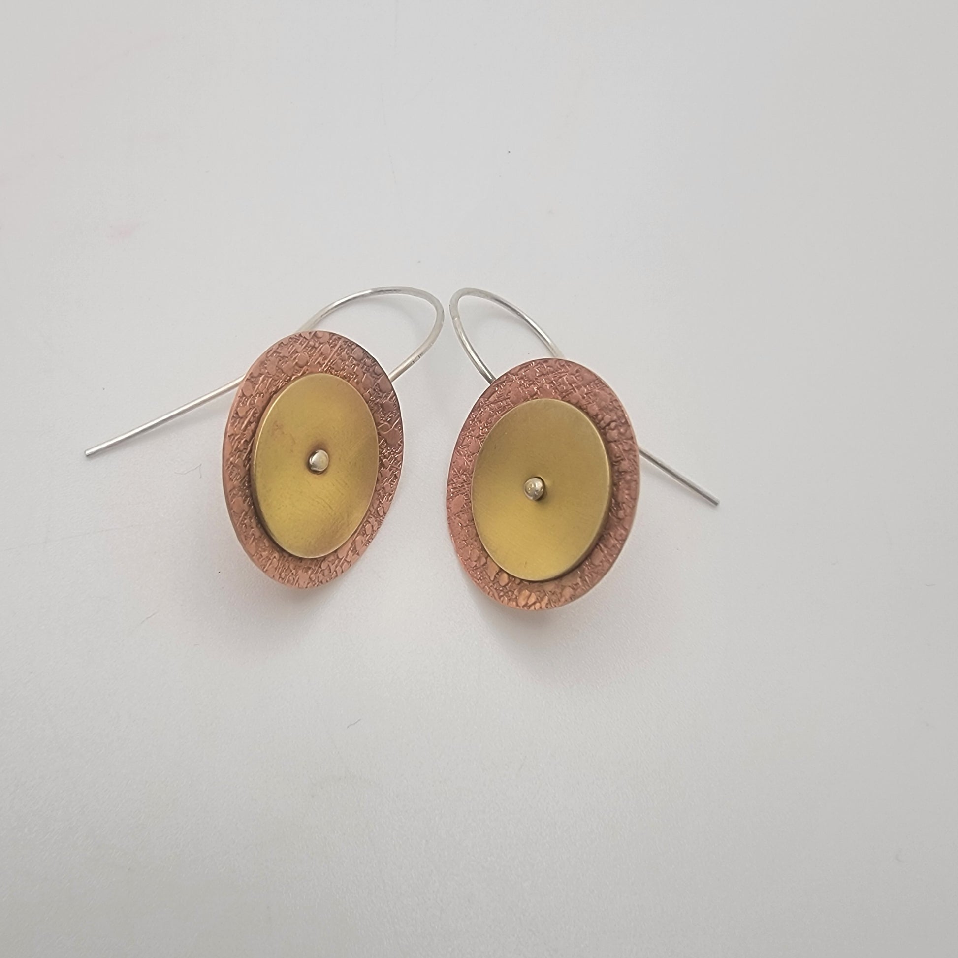 Pair of copper and brass disc earrings   on a white background