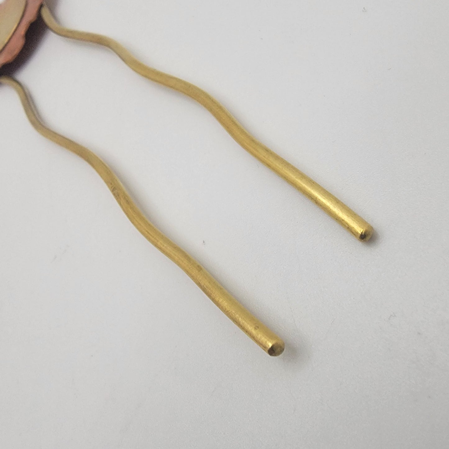 Gold hairpin on a light gray background
