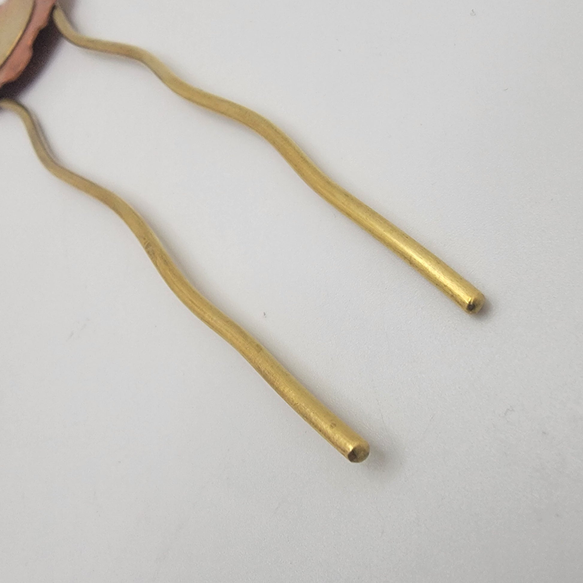 Gold hairpin on a light gray background