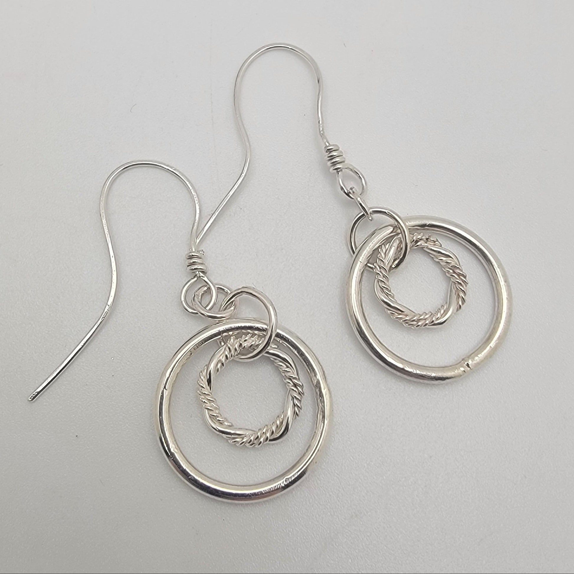 Silver hoop earrings on a light gray background