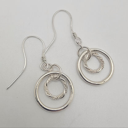 Silver hoop earrings on a light gray background