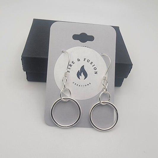 Silver earrings on a logo jewelry card on a gray background