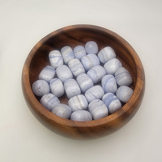 Blue lace nugget beads in a wood bowl on a white background