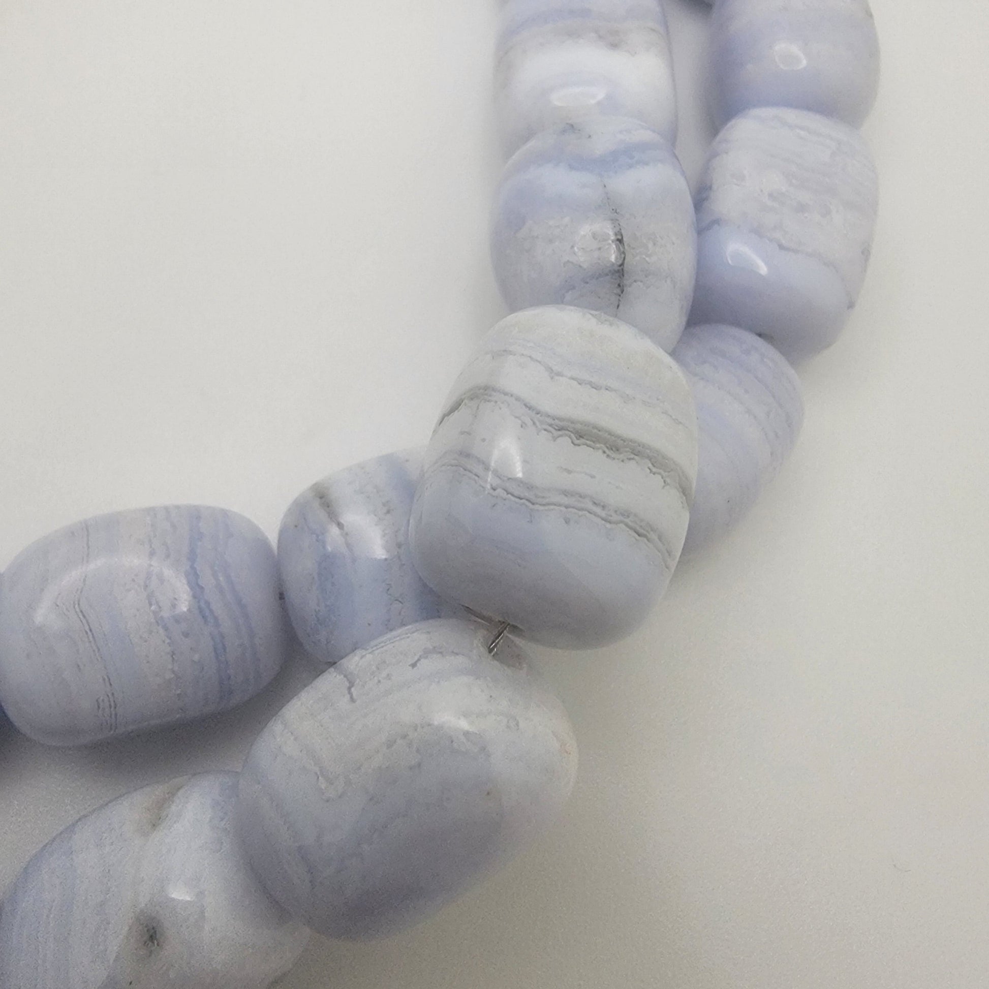 Stack of blue lace agate beads on a white background