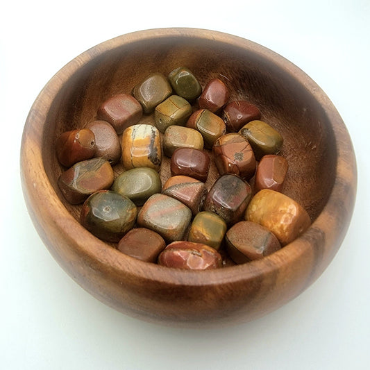 red nugget shaped beads in a wood bowl on white background