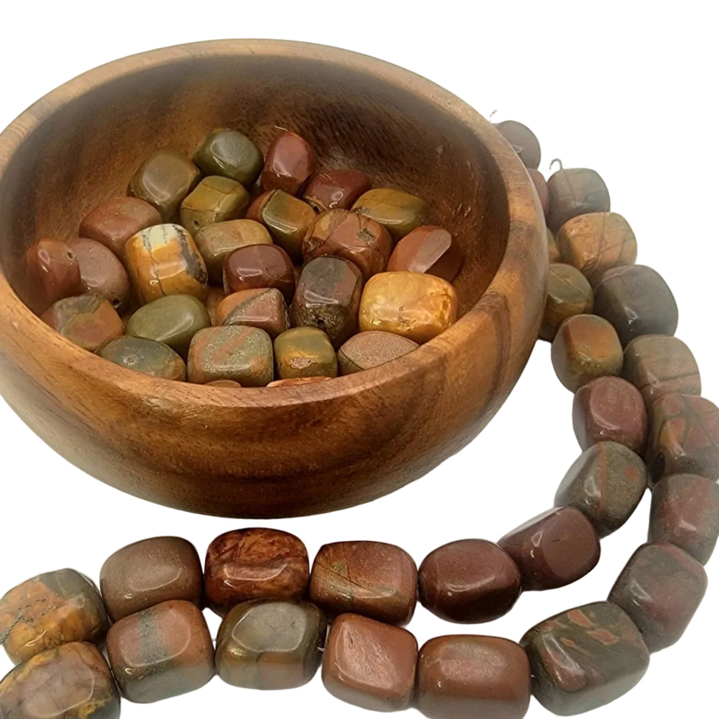 Wooden bowl filled with polished stones next to a string of similar stones on a white background