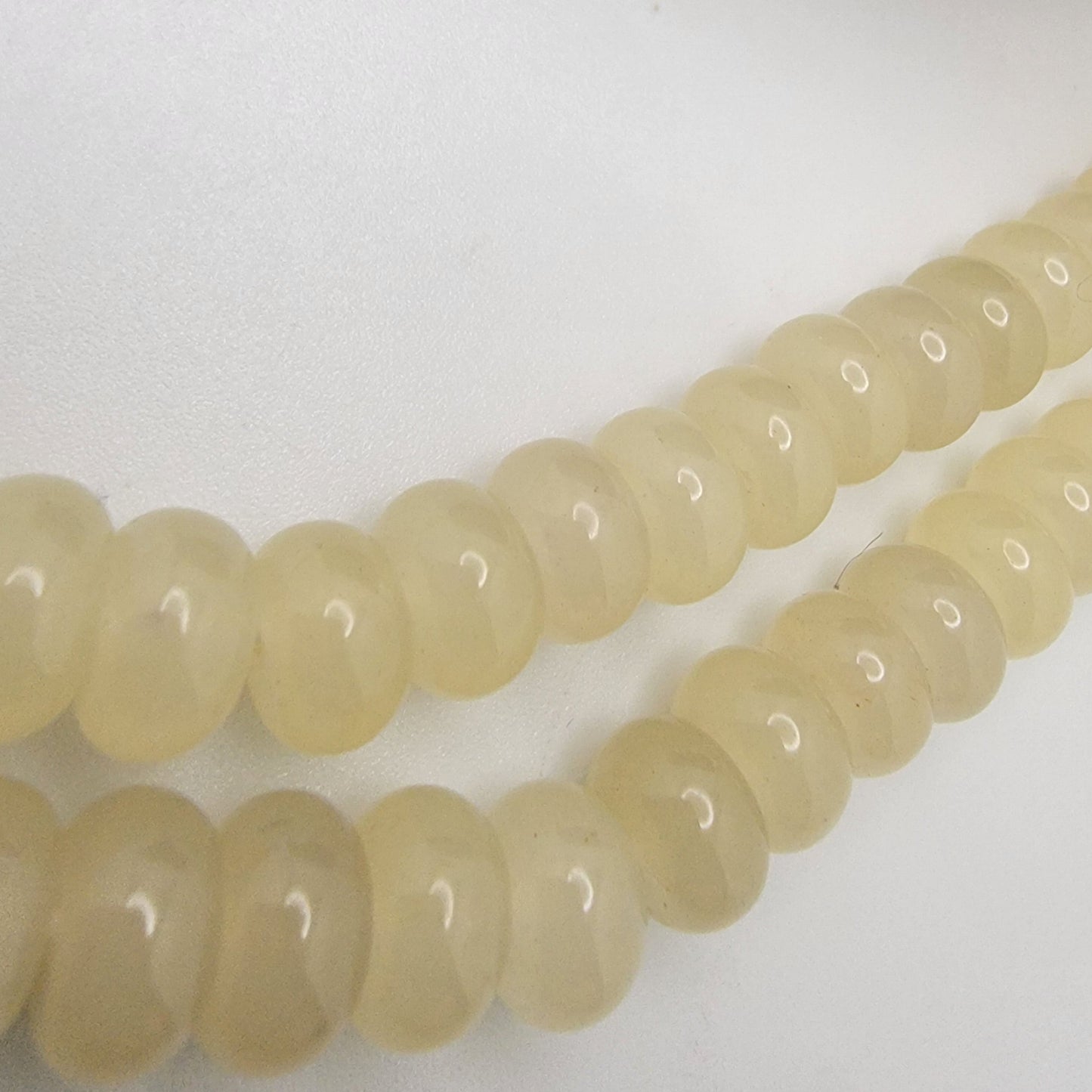 String of light-colored beads on a white surface