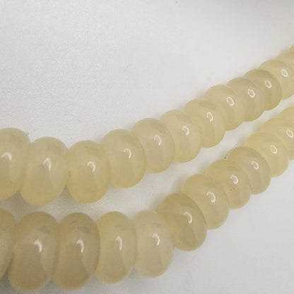 String of light-colored beads on a white surface