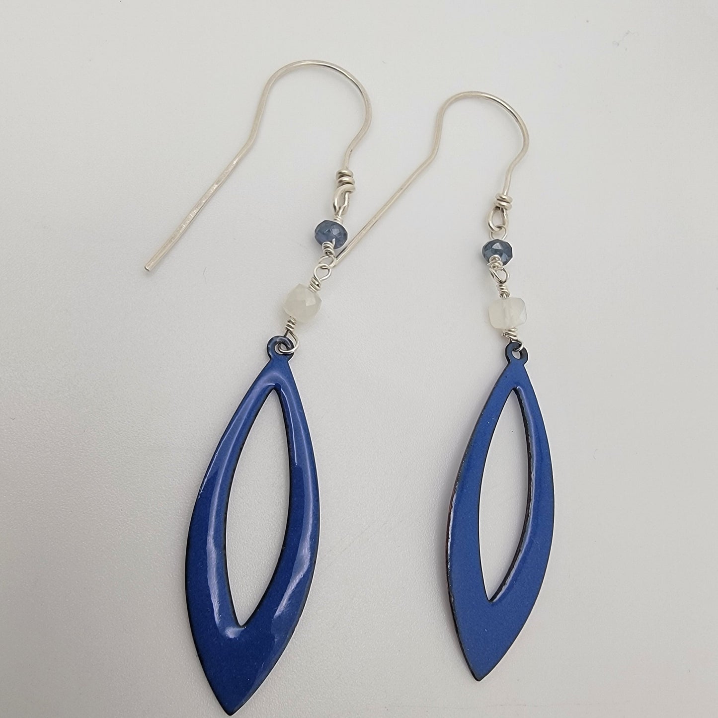 Blue teardrop-shaped earrings on a light gray background