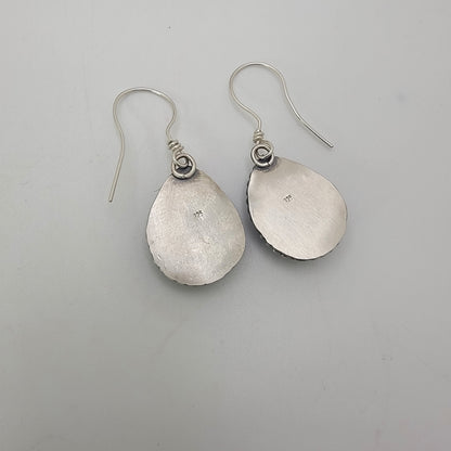 Back view of silver earrings on a white background