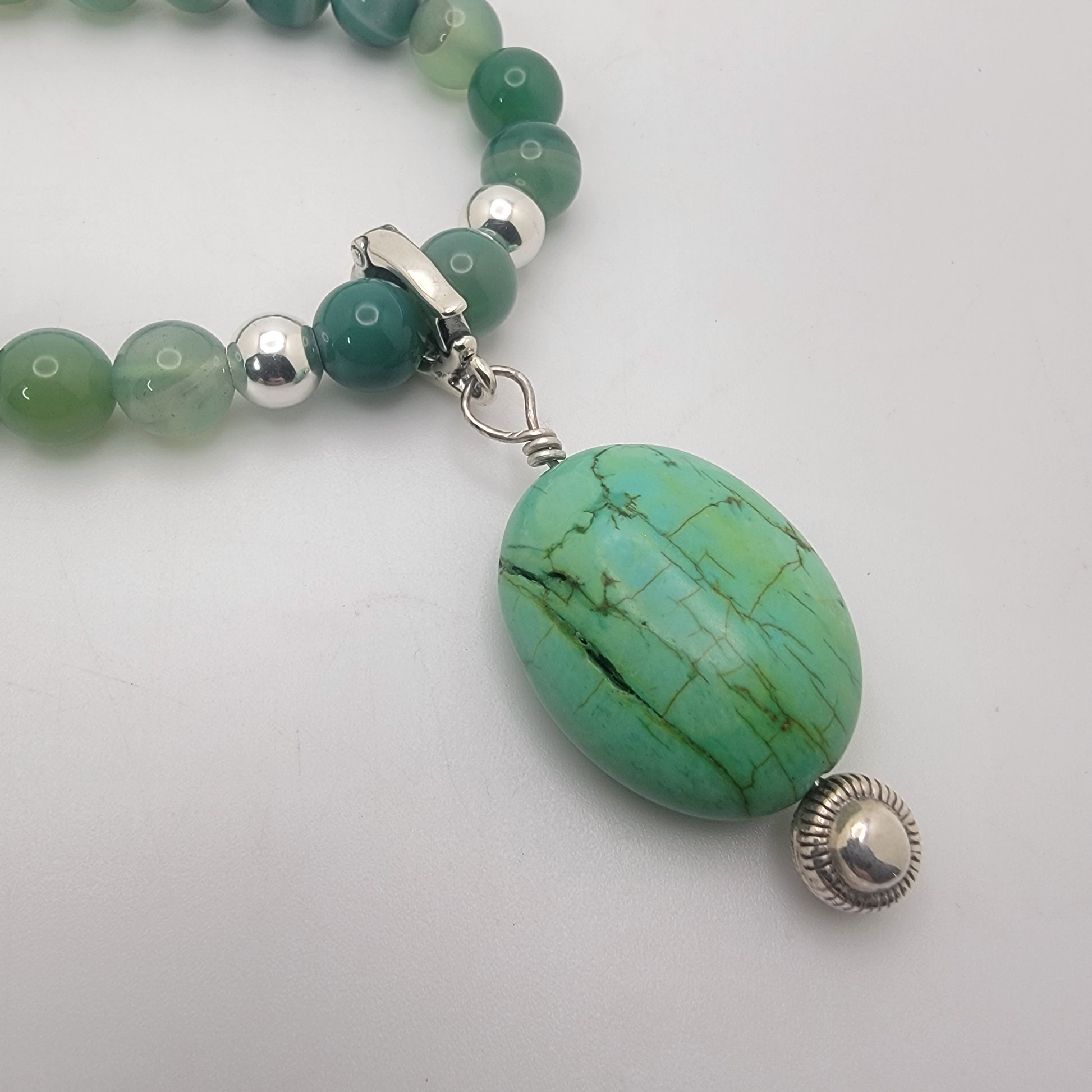 Handcrafted green agate necklace with turquoise focal bead and sterling silver accent beads.