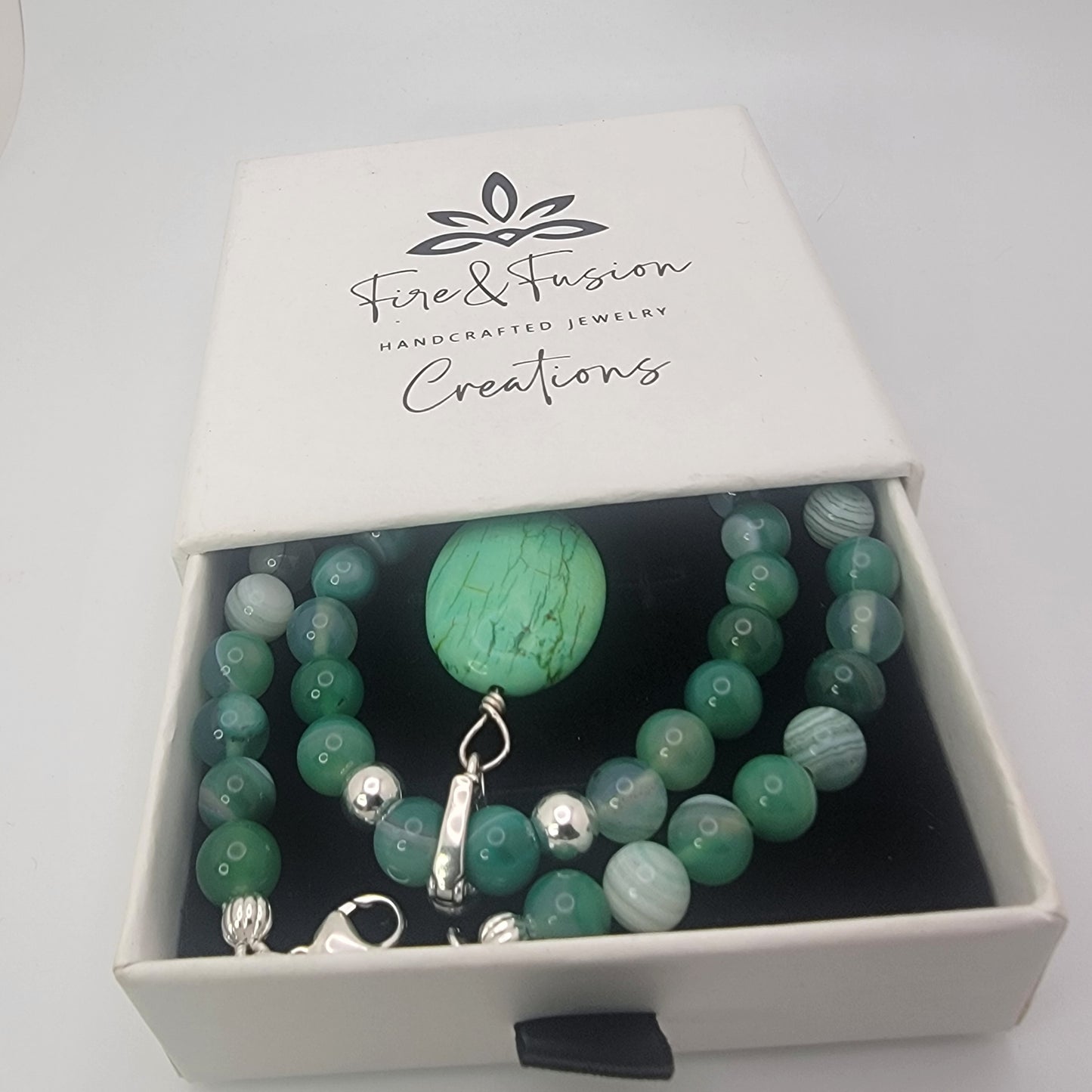 Green agate and turquoise gemstone necklace displayed in branded Fire and Fusion Creations gift box.