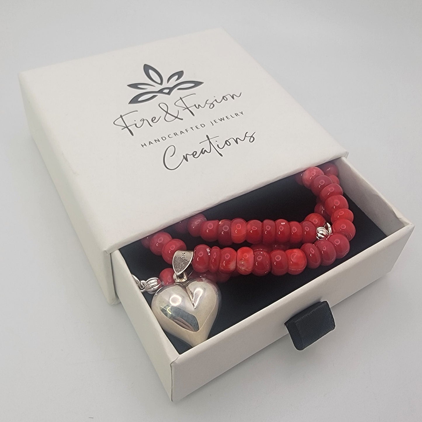 Red beaded neckalce with silver heart in white branded slider gift box with black insert