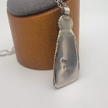 Back of handcrafted 925 sterling silver opalized wood pendant showing solid silver setting.