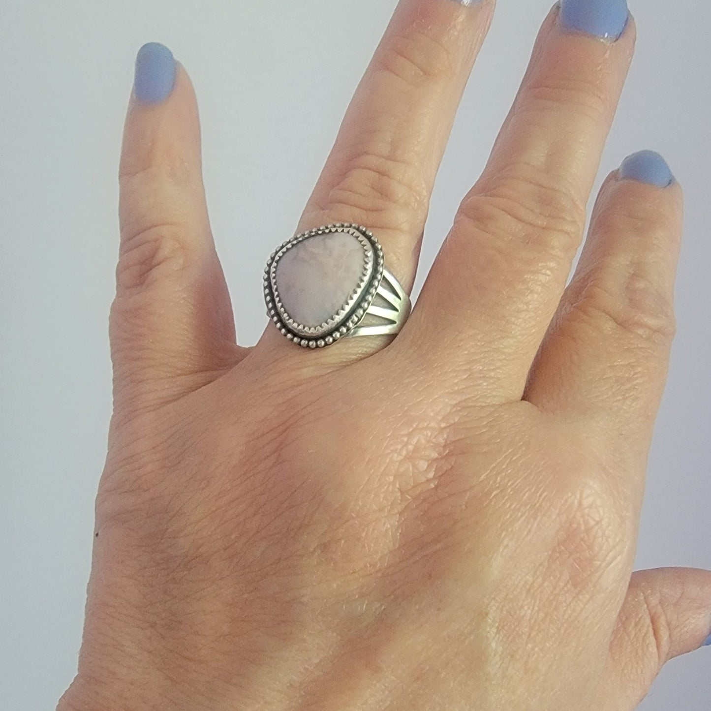 Pink gemstone and sterling silver ring with oxidized beaded detail shown on hand