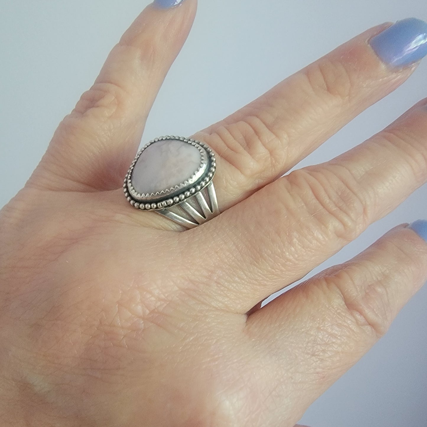 Pink gemstone and sterling silver ring with oxidized beaded detail shown on hand
