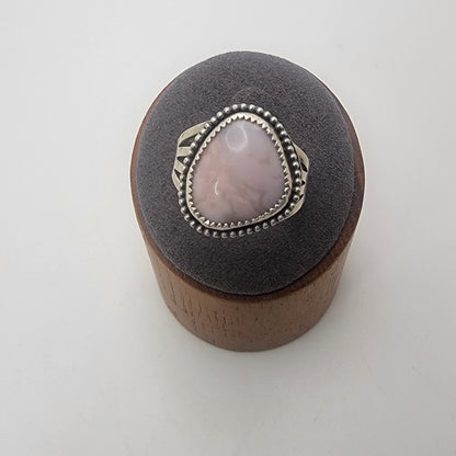 Pink gemstone and sterling silver ring with oxidized beaded detail shown on gray ring stand