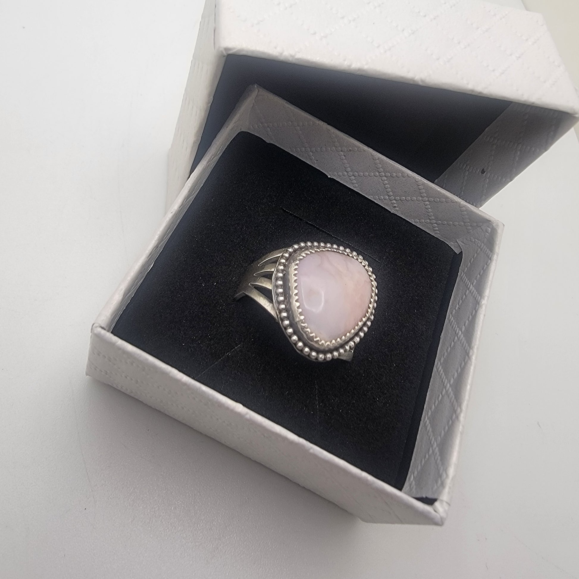 Pink gemstone and sterling silver ring with oxidized beaded detail shown on in white gift box with black insert