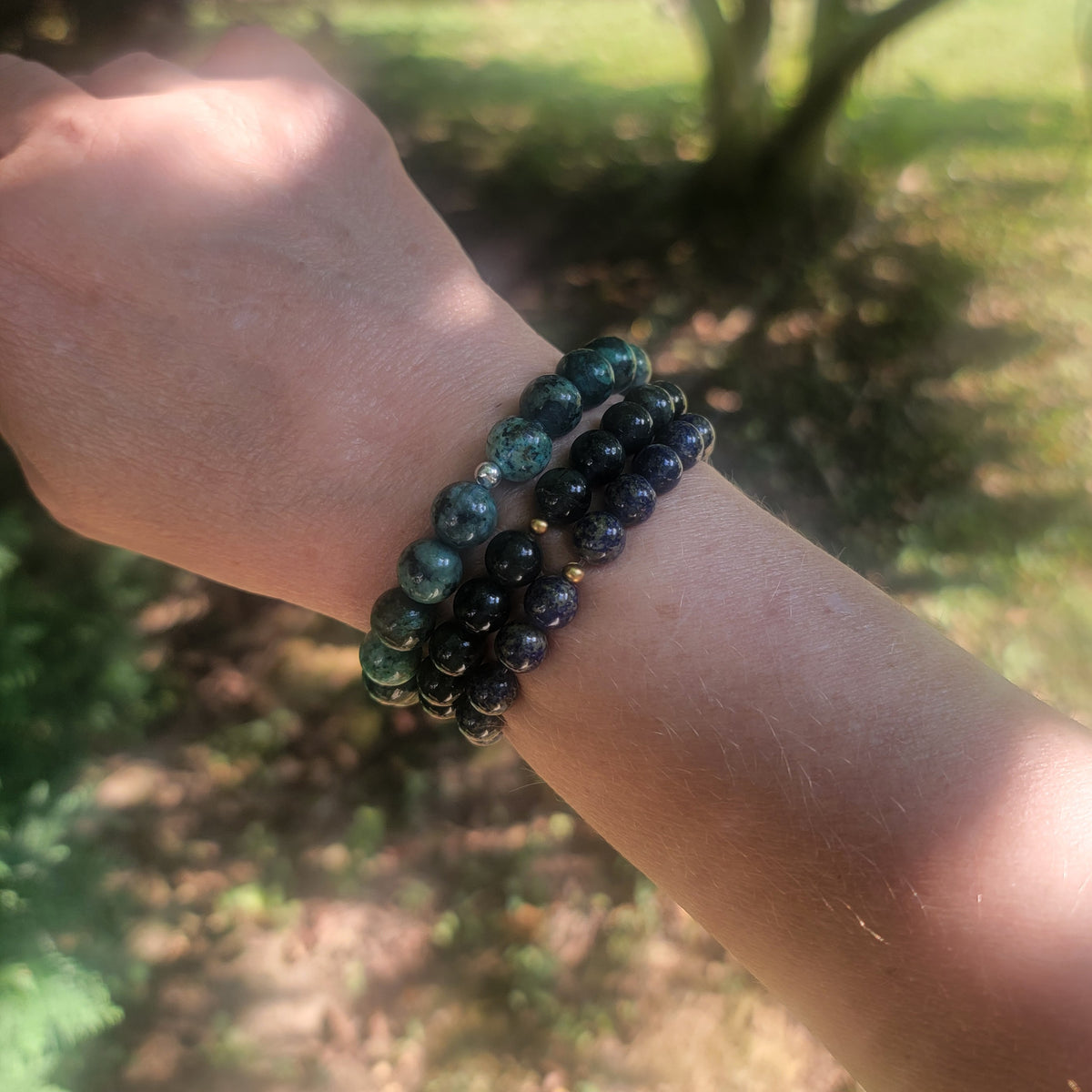 Handmade gemstone stretch bracelets in lapis lazuli, green jade and African Turquoise Jasper worn as a stack.