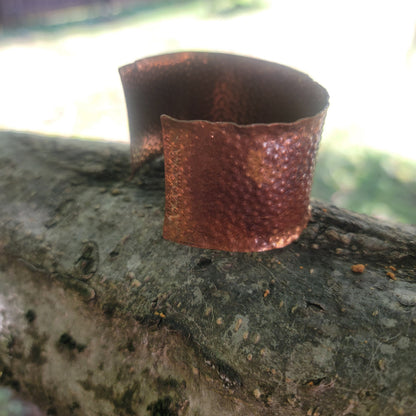 Angled view of textured copper cuff showing its curved shape.