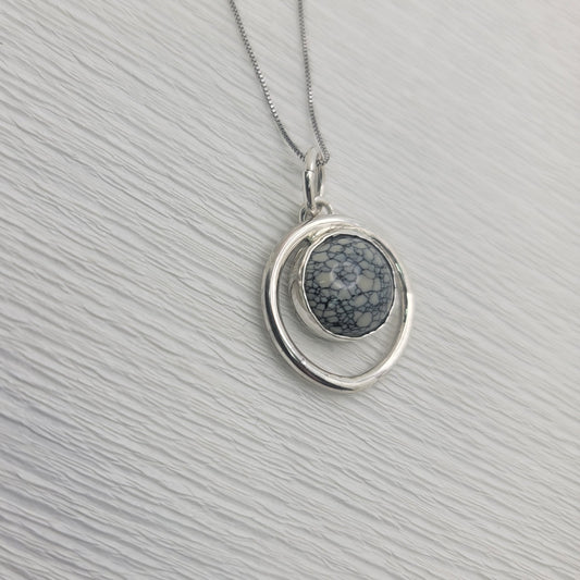 Variscite circle pendant and sterling silver box chain on a light textured background.
