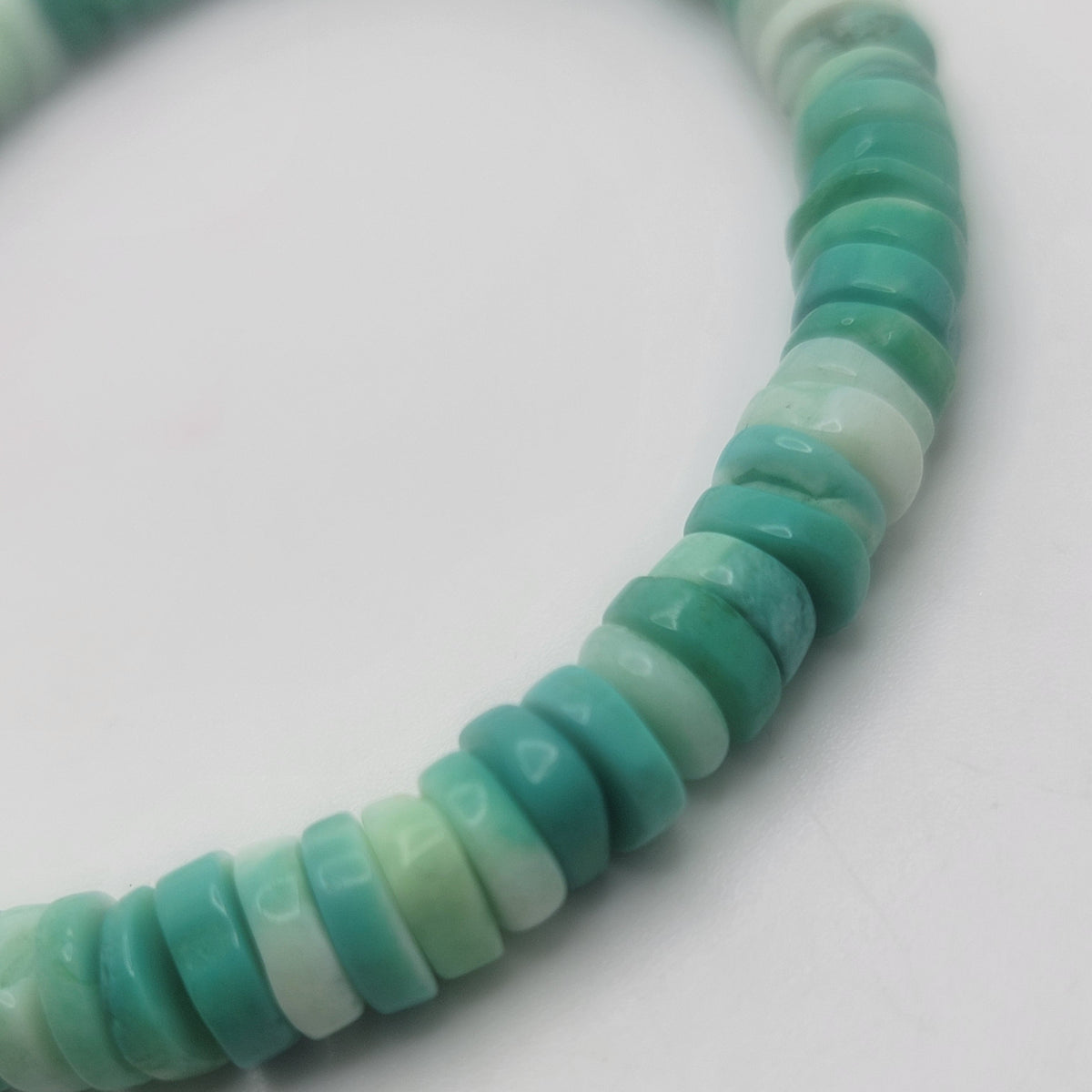 Close up of Peruvian Opal beads on a white background.