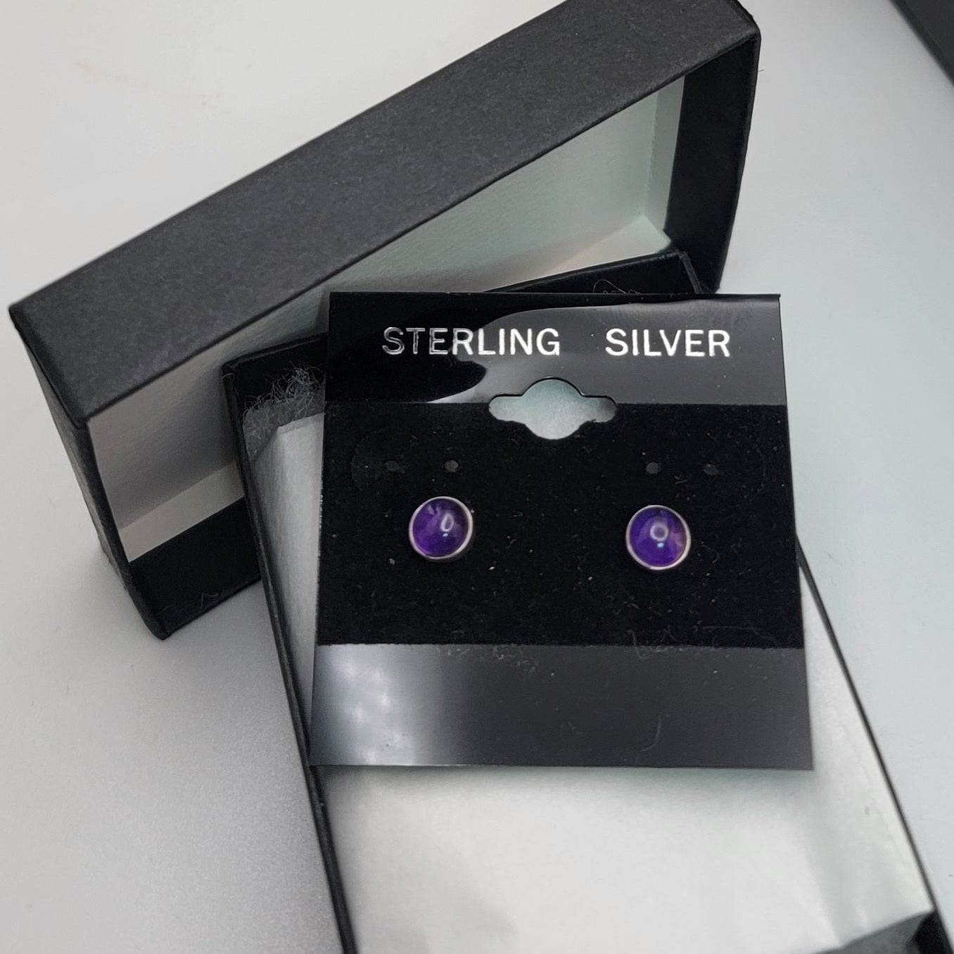 Sterling silver earrings in a black box with 'STERLING SILVER' text.