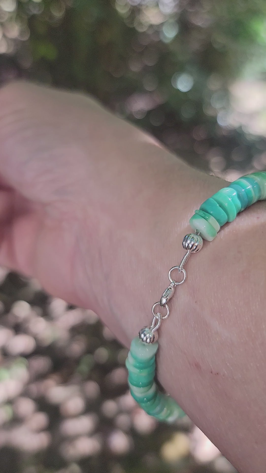 Green Peruvian opal beaded bracelet finished with a sterling silver lobster clasp worn on a wrist.