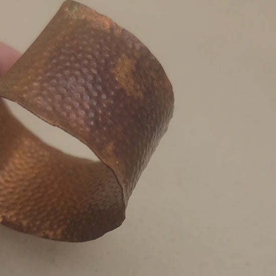 A video of a hammered and textured dimpled copper cuff bracelet being rotated to view all angles of the bracelet