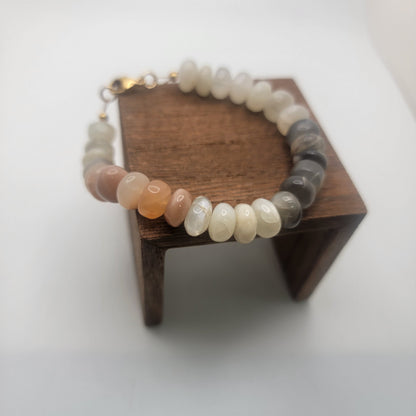 Moonstone beaded bracelet on wood platform on white background