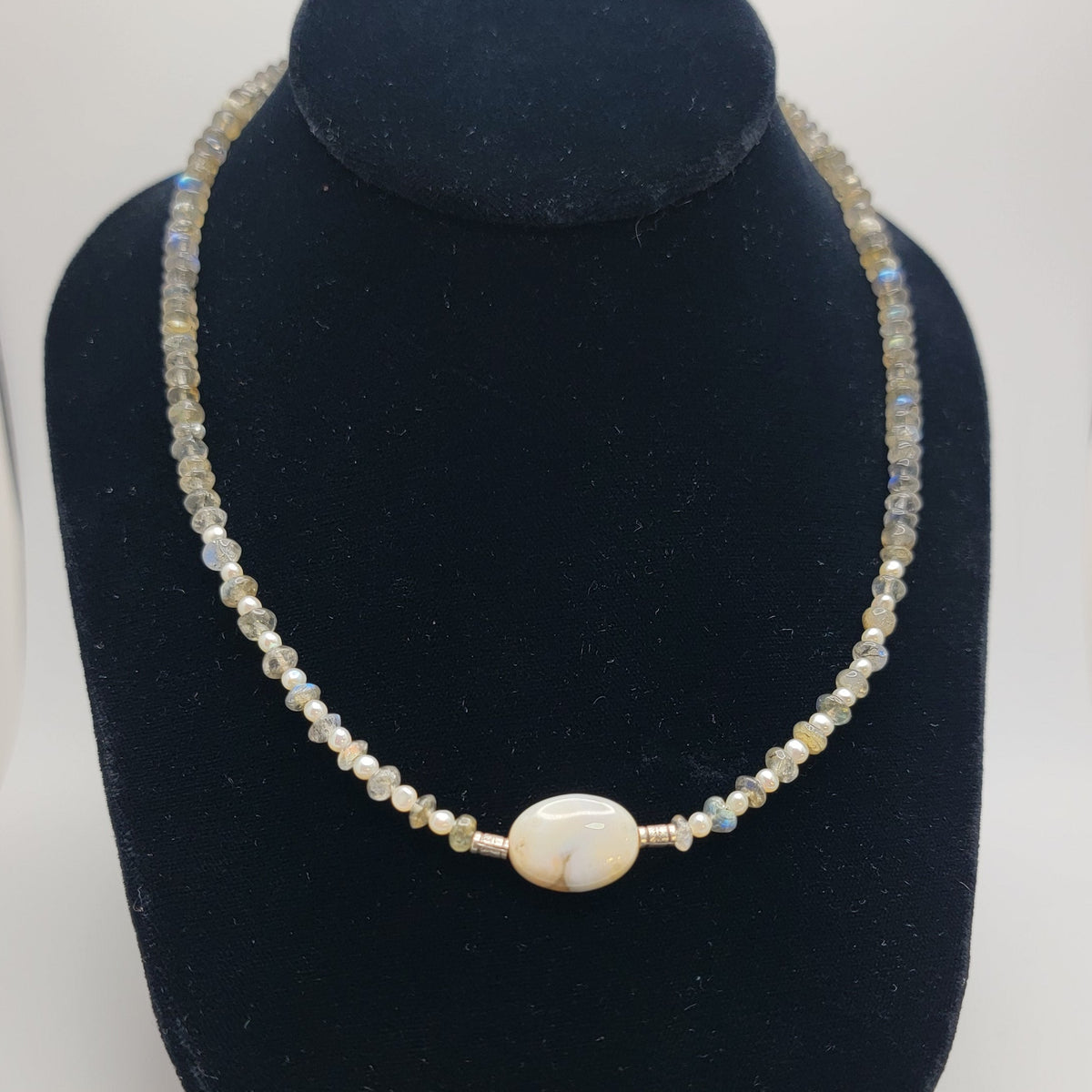 Labradorite and agate focal bead necklace on a black necklace bust on a white background