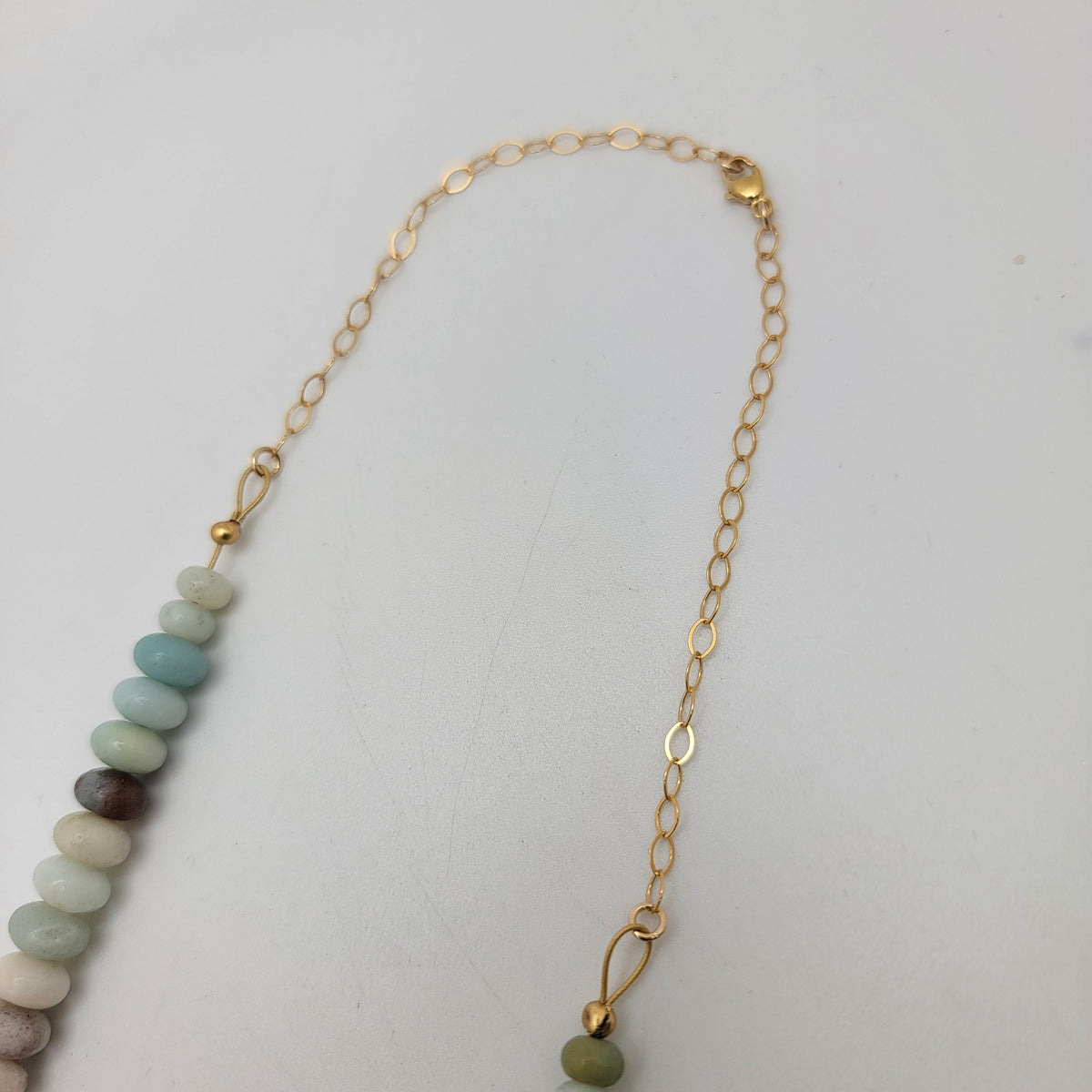 Gold tone chain with gold tone lobster clasp on a white background