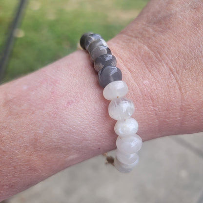 Moonstone beaded bracelet being worn on wrist in natural outdoor environment