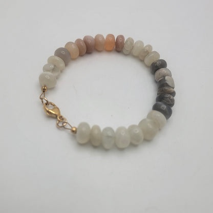 Moonstone beaded bracelet with gold colored clasp on white background