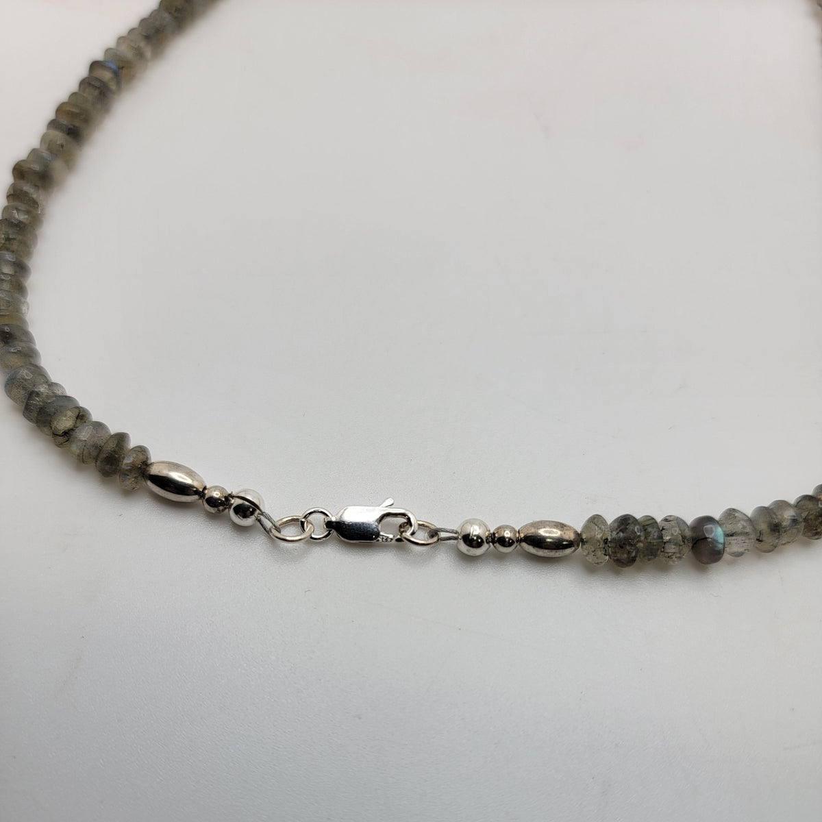 Labradorite bead necklace with a sterling silver lobster clasp on a white background